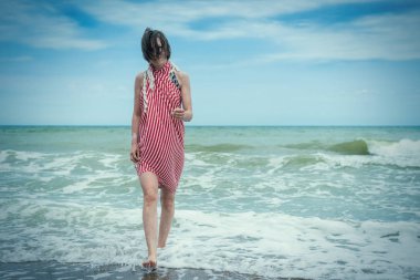 Çekici orta yaşlı kadın denizde, okyanusta suyun üzerinde yürüyor.