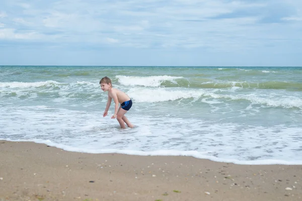 एक छोटा लड़का समुद्र से बाहर आता है . — स्टॉक फ़ोटो, इमेज