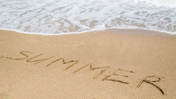 La palabra Verano escrito en la playa, el océano en la arena . —  Fotos de Stock