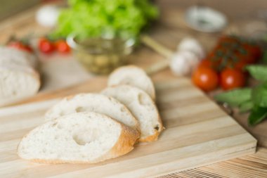 Dilimlenmiş ekmek, tahta zeminüzerine ciabatta. Bruschetta hazırlanması için hazırlık.