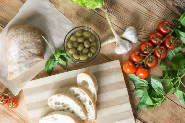Bruschetta pişirme için Malzemeler: doğranmış ciabatta, zeytin, domates, ahşap bir arka plan üzerinde mavi peynir. Sağlıklı ve lezzetli yemekler pişirme.