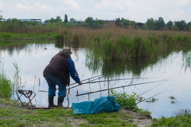 Bir adam balıkçı gölde balık yakalar.