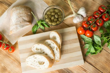 Bruschetta pişirme için Malzemeler: doğranmış ciabatta, zeytin, domates, ahşap bir arka plan üzerinde mavi peynir. Sağlıklı ve lezzetli yemekler pişirme.