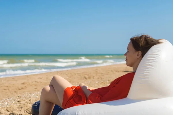 Una mujer está descansando en el mar mientras está sentada en una silla inflable —  Fotos de Stock