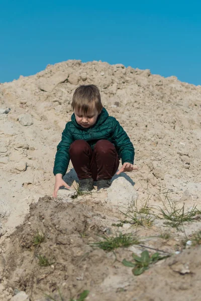 Маленький мальчик взбирается на песчаную гору . — стоковое фото