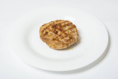 Beyaz bir arka planda beyaz bir plaka üzerinde et kızartma pirzola.