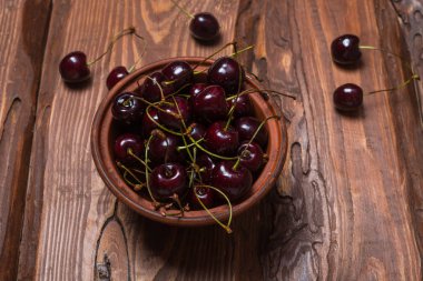 Ahşap bir arka plan üzerinde bir tabakta taze tatlı tatlı kiraz.