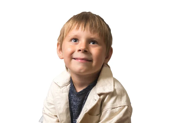 Menino atraente 5-7 anos de idade em uma jaqueta branca está sorrindo em um fundo branco. Isolados — Fotografia de Stock