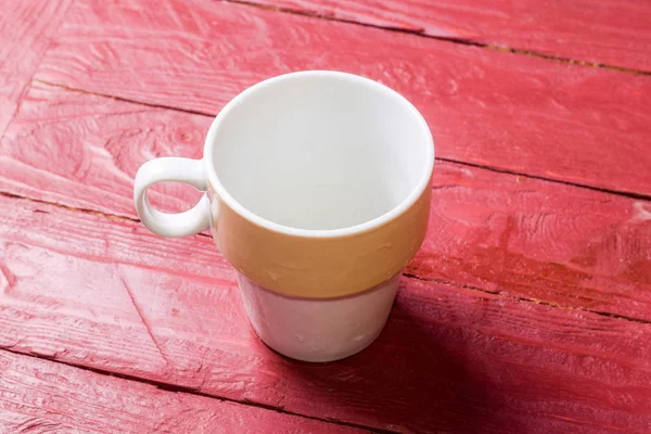 Leere Tasse auf weinrotem Hintergrund. — Stockfoto