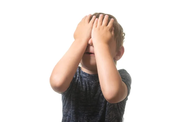 Pequeño niño está gritando con las manos cerradas ojos aislados sobre fondo blanco . — Foto de Stock