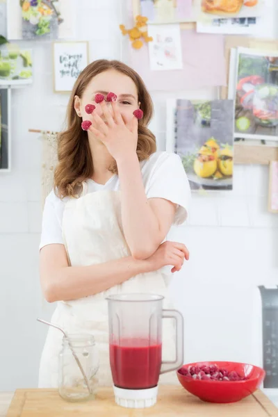 Batidos de frambuesa Una mujer pone bayas de frambuesa congeladas en una coctelera. El concepto de alimentación saludable . — Foto de Stock