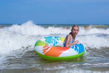 Denizde şişme bir daire üzerinde bir dalga üzerinde Kız, okyanus.