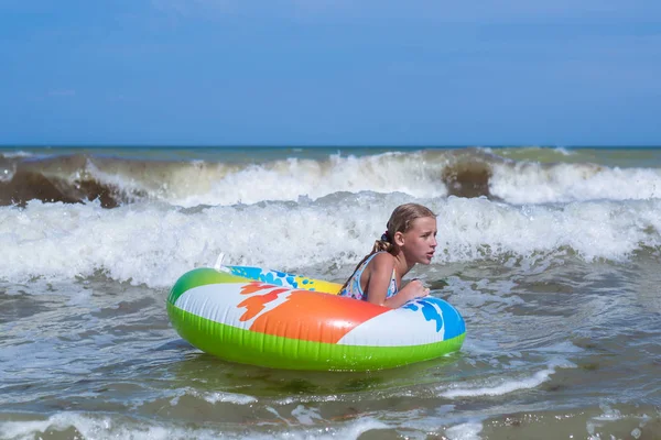 समुद्र में एक Inflatable सर्किल पर एक लहर पर लड़की, महासागर . — स्टॉक फ़ोटो, इमेज