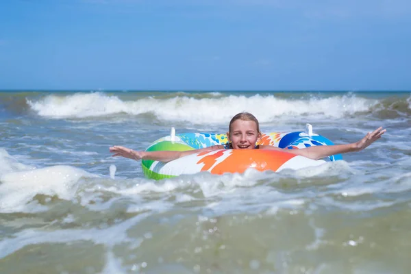 Девочка-подросток на надувном круге морской волны. Веселье на воде летом . — стоковое фото