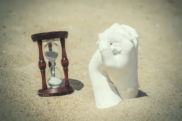 Пісочний годинник і штукатурка рук на піску. Концепція об'єднання зусиль для досягнення цілей . — стокове фото