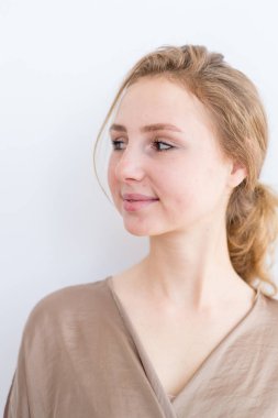 Beyaz bir arka plan üzerinde kahverengi saçlı çekici, güzel genç kız. Öğrenci hayatı kavramı, gençlik.