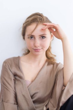 Beyaz bir arka plan üzerinde kahverengi saçlı çekici, güzel genç kız. Öğrenci hayatı kavramı, gençlik.