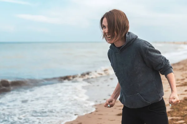 Una donna arrabbiata e frenetica grida emozioni negative sul mare, sull'oceano. Espressione dei sentimenti, liberazione dal concetto di negatività. Urla come mezzo di espressione . — Foto Stock