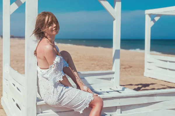 Vila på havet, oceanen. En medelålders kvinna i en vit klänning på havet i varmt soligt väder. Ha kul på semester på sommaren. — Stockfoto