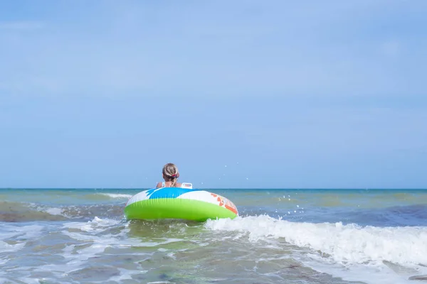 Девочка-подросток на надувном круге в море, океане. Плавать во время волн . — стоковое фото