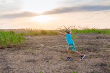 Küçük bir çocuk uçakta oynuyor. Bir çocuk, kollarını alan üzerinde koşuyor ve kendini bir pilot olarak hayal etti..