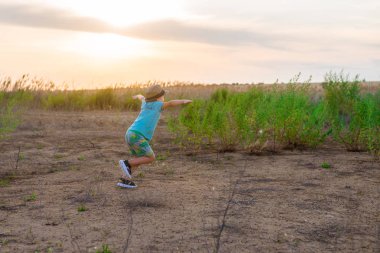Küçük bir çocuk uçakta oynuyor. Bir çocuk, kollarını alan üzerinde koşuyor ve kendini bir pilot olarak hayal etti..
