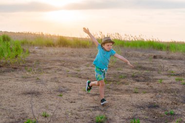 Küçük bir çocuk uçakta oynuyor. Bir çocuk, kollarını alan üzerinde koşuyor ve kendini bir pilot olarak hayal etti..