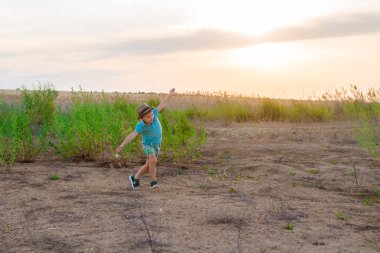 Küçük bir çocuk uçakta oynuyor. Bir çocuk, kollarını alan üzerinde koşuyor ve kendini bir pilot olarak hayal etti..