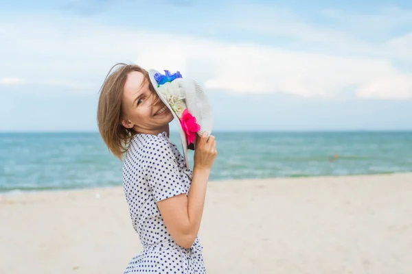 Medelålders kvinna i hatt och klänning på havsstranden, Ocean. Fritid, semester, Serenity, frihet Concept. — Stockfoto