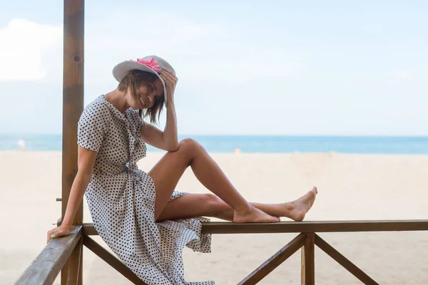 Happy middle-aged woman resting on the veranda, gazebo on the beach, ocean.