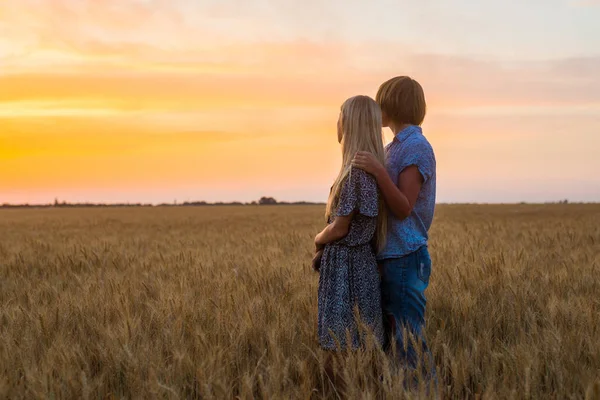 Mom of middle age and daughter teenager in a field at sunset. Relationship, understanding between parent and child.