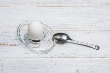 Beyaz ahşap arka planda haşlanmış yumuşak haşlanmış tavuk yumurtası.