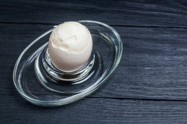 Siyah ahşap arka planda haşlanmış yumuşak haşlanmış tavuk yumurtası.