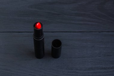 Siyah ahşap arka planda kırmızı ruj.
