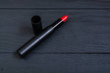 Siyah ahşap arka planda kırmızı ruj.