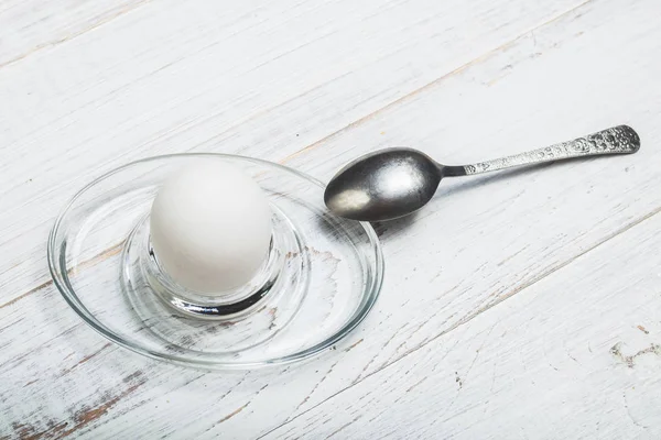 Ovo de frango cozido macio em um fundo de madeira branco . — Fotografia de Stock