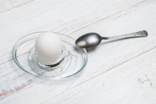 Ovo de frango cozido macio em um fundo de madeira branco . — Fotografia de Stock