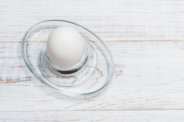 Ovo de frango cozido macio em um fundo de madeira branco . — Fotografia de Stock