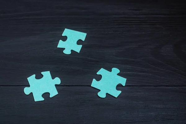 Puzzles on a black wooden background.