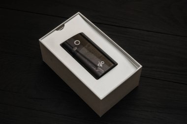 Kiev, Ukrayna-28 Temmuz 2019: sigara için elektronik cihaz ile bir kutu siyah ahşap arka planda GLO.