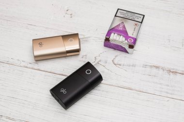 Kiev, Ukrayna-28 Temmuz 2019: GLO-Beyaz ahşap arka planda sigara için tütün ve ambalaj çubukları Isıtma için bir cihaz.