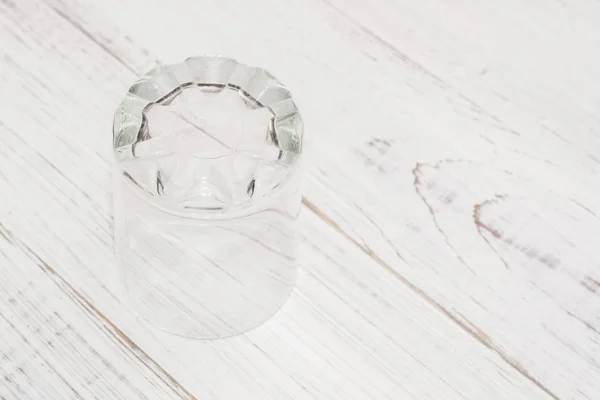 Verre vide sur un fond en bois blanc . — Photo