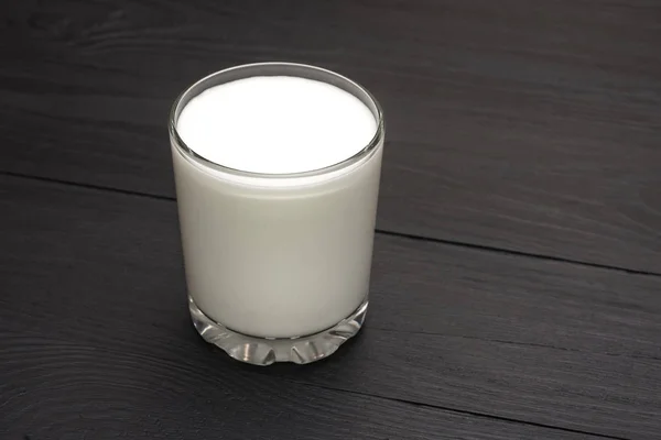 Kaca dengan kefir, yogurt, susu dengan latar belakang kayu hitam . — Stok Foto