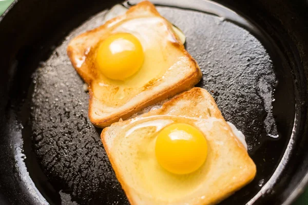 Готовить тосты с жареным яйцом в сковороде. Сэндвич с куриным яйцом. Закуска, завтрак . — стоковое фото