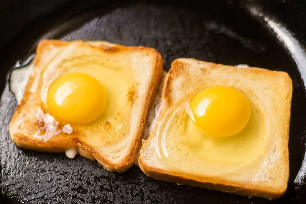 Готовить тосты с жареным яйцом в сковороде. Сэндвич с куриным яйцом. Закуска, завтрак . — стоковое фото
