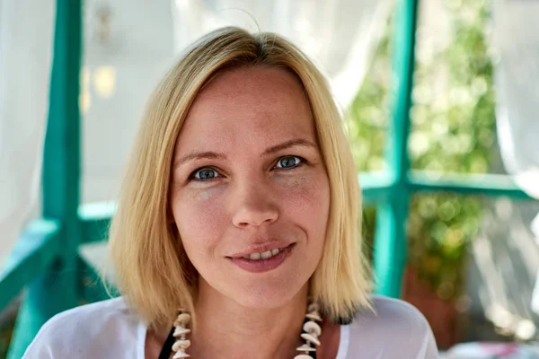 Açık havada yaz aylarında makyaj olmadan çekici bir gülümseyen orta yaşlı kadın portresi.