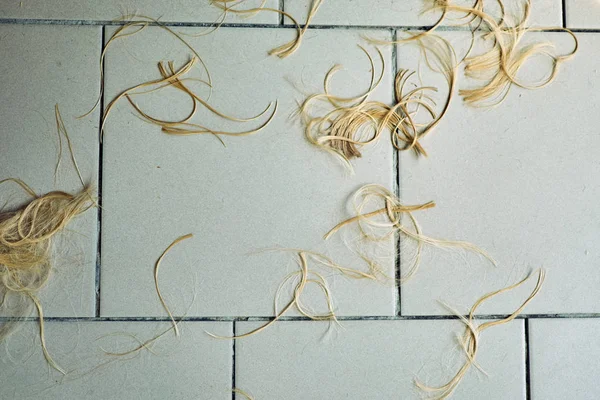 Memangkas rambut pirang di lantai parimmecher . — Stok Foto