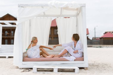 Anne ve kızı yaz aylarında plajda bir bungalovda rahatlayın.