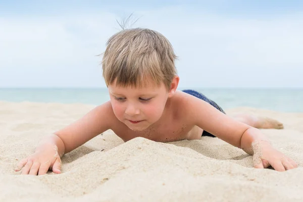 Chlapeček se baví na pláži. Zbytek dítěte na moři, oceán. — Stock fotografie