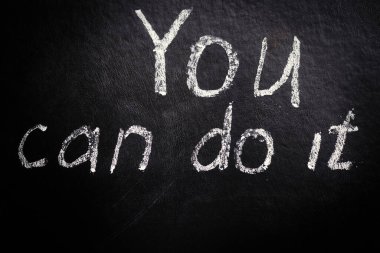 Başarabilirsin. Siyah bir arkaplanda tebeşirle motivasyon yazılımı.